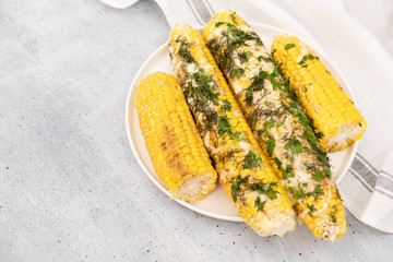 Grilled corn on cob sprinkled with parsley and grated parmesan