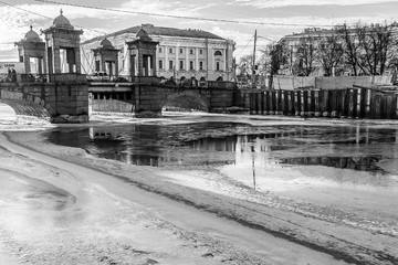 Winter cityscape of St. Petersburg with the freezing Fontanka river and a view of the Lomonosov bridge Sunset time
