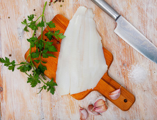 Raw seafood, fresh fillet halibut fish on wooden board