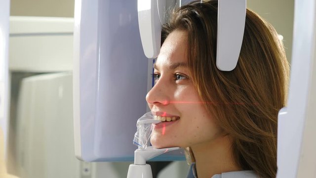 Dental jaw scanning. Laser lines on patient face. Female patient undergoing panoramic X-ray procedure of oral cavity using an orthopantomographic mashine in modern dentistry. 4 k video