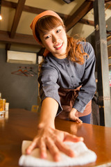 テーブルを拭く女性店員