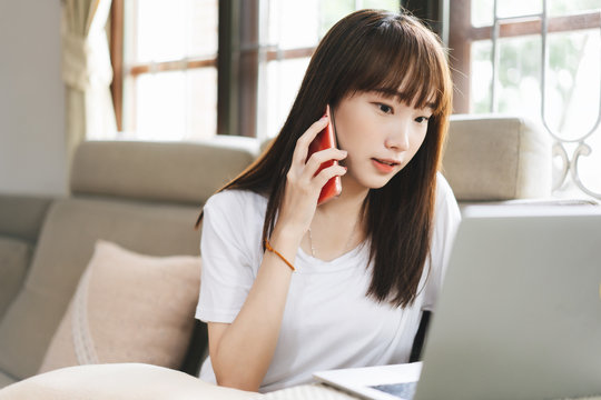 Teenager asian student woman education online via internet at home talk by mobile phone