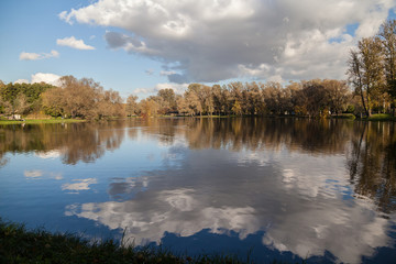 Fototapeta na wymiar Small lake autumn park landscape with bright trees