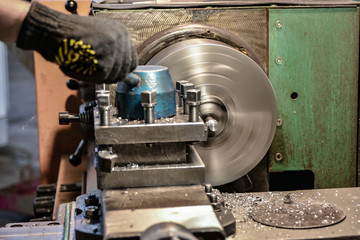 Working on a lathe, a cutter removes chips from the workpiece surface being processed.
