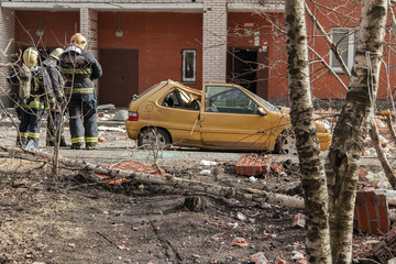 Russian rescuers at the site of the collapse of the wall of a brick apartment building. Destroyed...