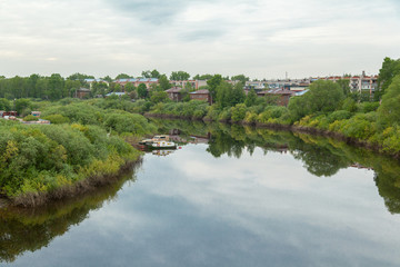 Fototapeta na wymiar Summer russian river townscape of green embankment