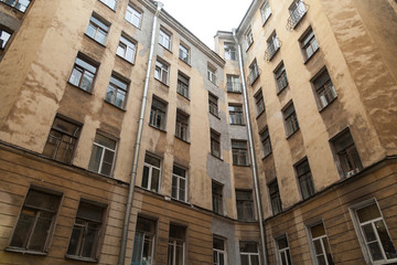 The courtyard of an old apartment building in St. Petersburg with yellow shabby walls
