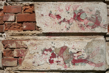 Abstract background with a texture of a natural old red brick wall with peeling plaster.