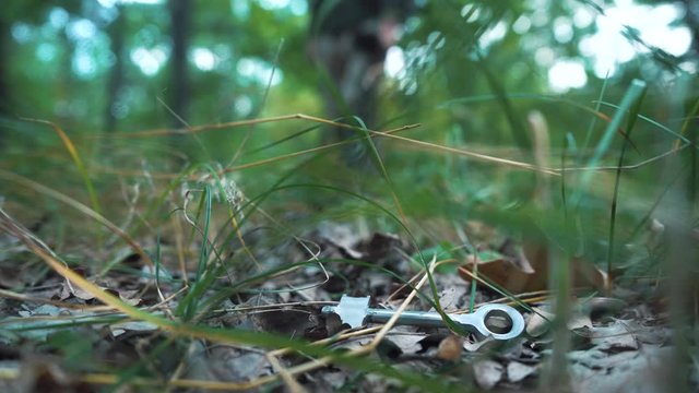 Metal detector. Man with electronic device searching finds a metal key.
