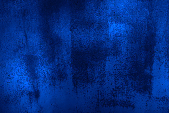 Dark blue grunge background. Old painted concrete wall. Close-up. Navy blue rough texture. Abstract blue grunge background.