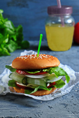 Vegetarian Burger with chickpeas, fresh cucumber, tomato, salad and sour cream sauce. The concept of healthy eating. An alternative to the usual hamburger. Vertical.
