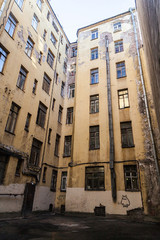 The courtyard of an old apartment building in St. Petersburg with yellow shabby walls