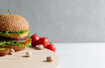 Fresh vegan chickpea burger with onion, tomatoes and lettuce. Home made with vegetables and...