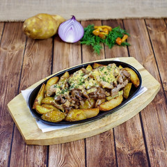 Potatoes with mushrooms on a wooden platter