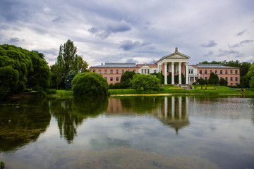 Historical building in a city Park with a pond in the background