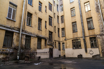 The courtyard of an old apartment building in St. Petersburg with yellow shabby walls