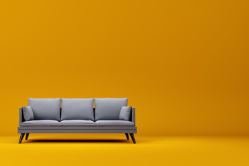 Grey couch with pillows on studio yellow background. - obrazy, fototapety, plakaty