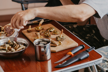 Hands cut raw mushrooms with sharp knife