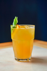 Refreshing cold citrus drink with mint. Cold summer beverage served in a glass. ALcohol cocktail on a wooden table