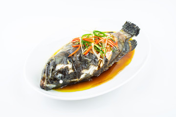A dish of Cantonese steamed grouper on white background