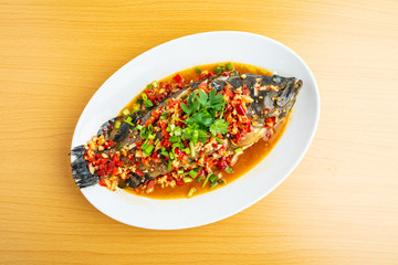 Braised grouper in a dish Chinese dish on wooden table