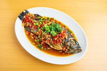 Braised grouper in a dish Chinese dish on wooden table