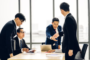 Image two asian business partners in elegant suit successful handshake together in modern office.Partnership approval and thanks gesture concept