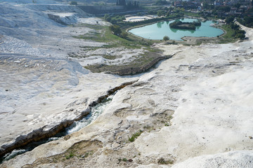 Natural landscape and Thermal pools of Pamukkale (Cotton castle) mineral-rich thermal waters flowing down white travertine terraces on a nearby hillside formed by ancient hot springs- Denizli, Turkey