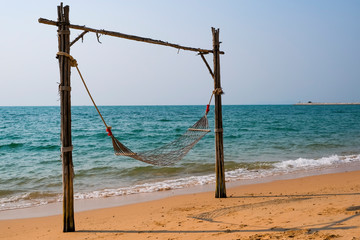 Obraz na płótnie Canvas Romantic cozy hammock on the tropical beach by the sea. Peaceful seascape. Relax, travel concept, travelling.