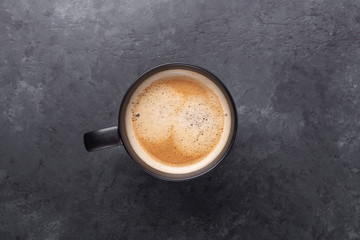 Cup cup of fresh coffee on on dark stone background. Top view. Copy space for your text