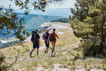 Group of tourists in mountains. Travellers on top of mountain. Vacation time. Adventure travel. Travelling concept