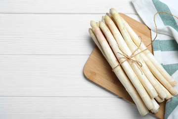 Fresh white asparagus on wooden table, top view. Space for text