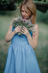 Portrait of beautiful blonde with bouquet of flowers