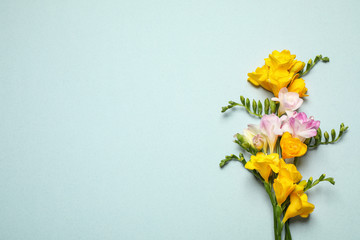 Beautiful blooming freesias on light background, flat lay. Space for text