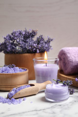 Fototapeta na wymiar Cosmetic products and lavender flowers on white marble table