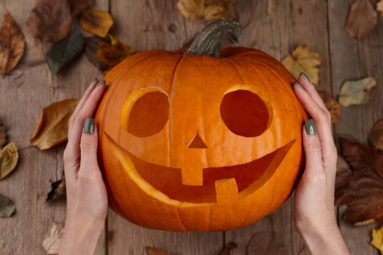 Woman holding pumpkin jack carved for Halloween holiday