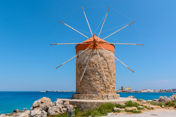 Fototapeta na wymiar Historic windmill overlooking Mandrakia port. Rhodes island, Greece
