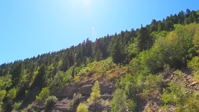 Slow motion pov point of view low angle driving in vehicle car on scenic road in Colorado on Million Dollar Highway 550 at San Juan national forest with canyons on route from Ouray to Durango