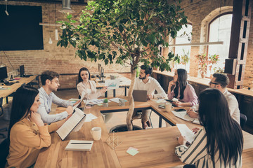Photo of business people partners sit around table spacious office seven members successful new...