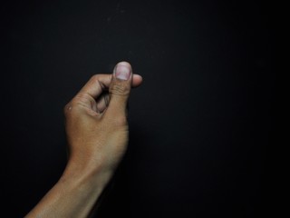 Male hand holding virtual card with fingers isolated on black background