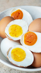 Chicken egg and duck egg in a white bowl.