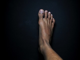 Close-up male feet isolated on black background