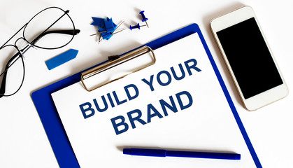 BUILD YOUR BRAND text on the paper with office tools