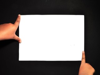 Hand holding white paper isolated on black background. Close-up hand holding blank sheet