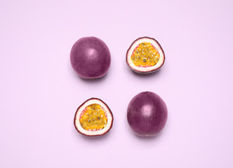 Fresh ripe passion fruits (maracuyas) on light violet background, flat lay