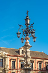Fototapeta na wymiar Seville, Spain. October 15th, 2020. Beautiful baroque style street lamp in Plaza Virgen de los Reyes in front of the historic Archbishop's Palace.