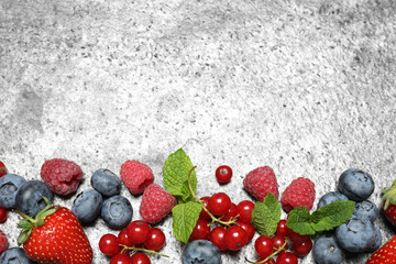 Different fresh berries on grey background, flat lay. Space for text