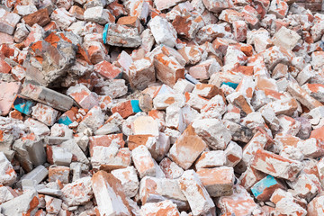 Pile of broken red bricks at construction site, waste. Abstract stone texture, rock background.
