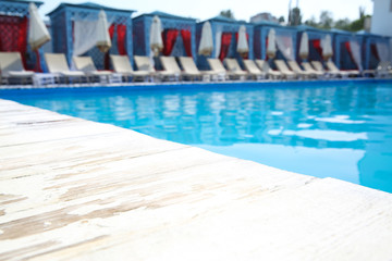 Outdoor swimming pool with sunbeds at resort on sunny day