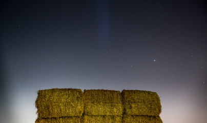 Long exposure night scene of isolated square haystacks on a rural farm field- Israel